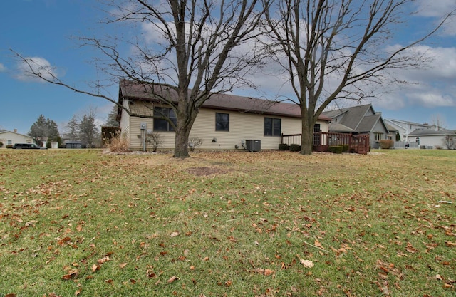 back of property with central AC unit, a yard, and a deck