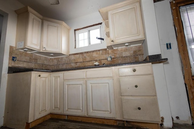 kitchen featuring tasteful backsplash, dark stone counters, and cream cabinets