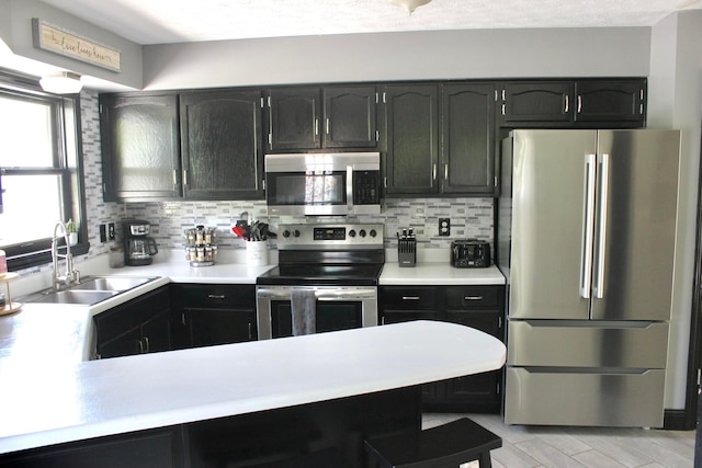 kitchen with stainless steel appliances, sink, and backsplash