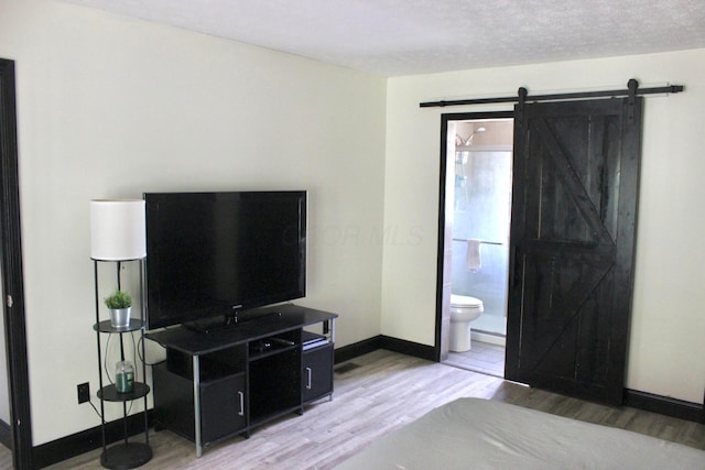 living room featuring a barn door, hardwood / wood-style floors, and a textured ceiling