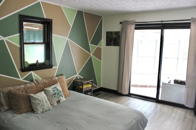 bedroom with hardwood / wood-style floors and a textured ceiling