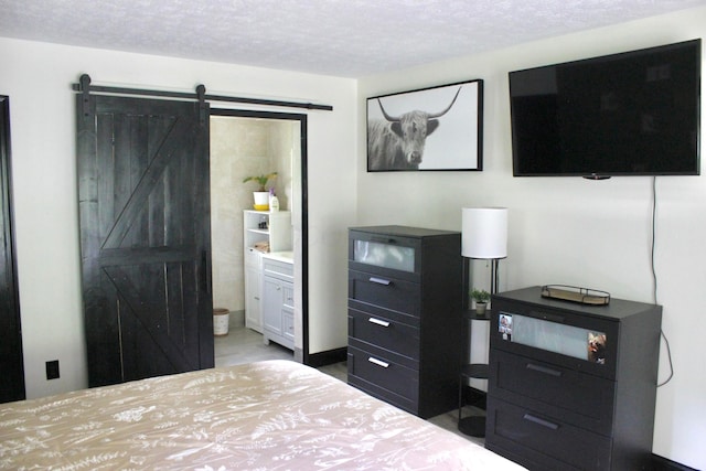 bedroom with a barn door and a textured ceiling