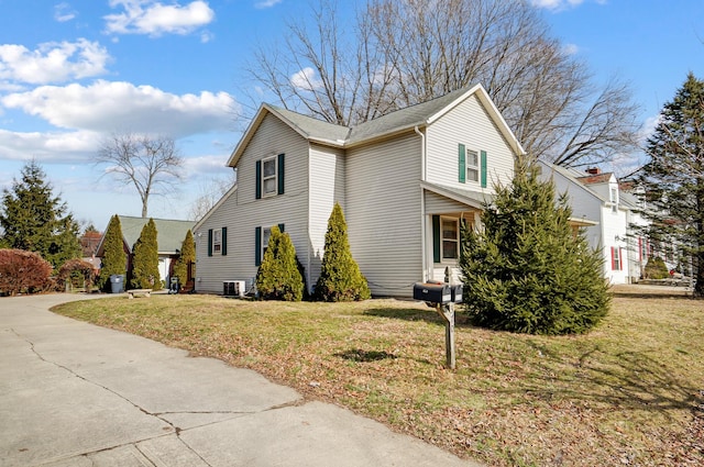 view of side of property featuring central AC unit and a lawn