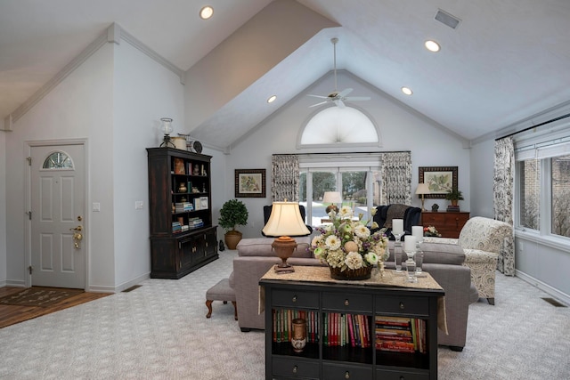 living room with ceiling fan, high vaulted ceiling, and light carpet