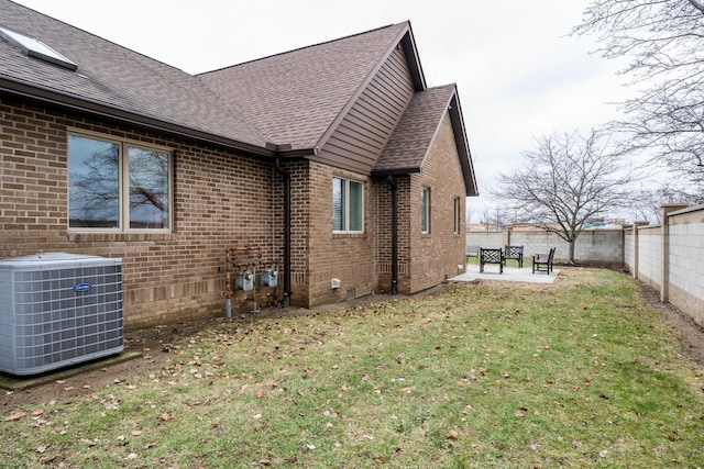 view of home's exterior with a patio, central AC, and a lawn