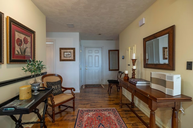 hall with dark wood-type flooring and a textured ceiling