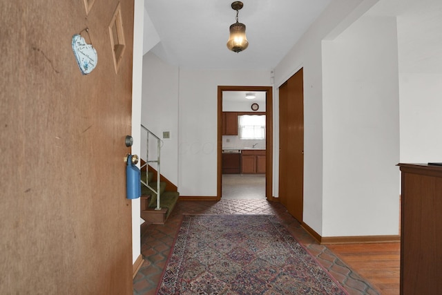 corridor featuring stairs and baseboards