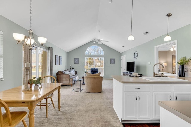 kitchen with a wealth of natural light, ceiling fan with notable chandelier, and a sink