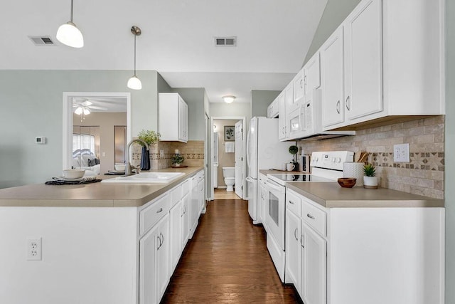 kitchen featuring visible vents, a peninsula, a sink, white cabinets, and white range with electric stovetop