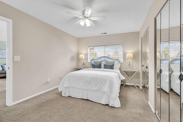 bedroom with visible vents, baseboards, light colored carpet, and a ceiling fan