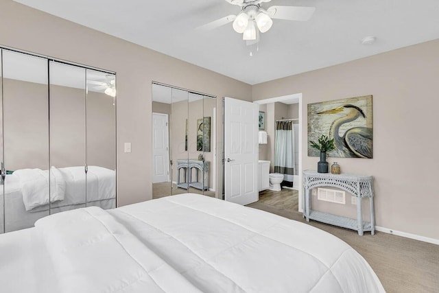 bedroom with ensuite bath, baseboards, multiple closets, and a ceiling fan