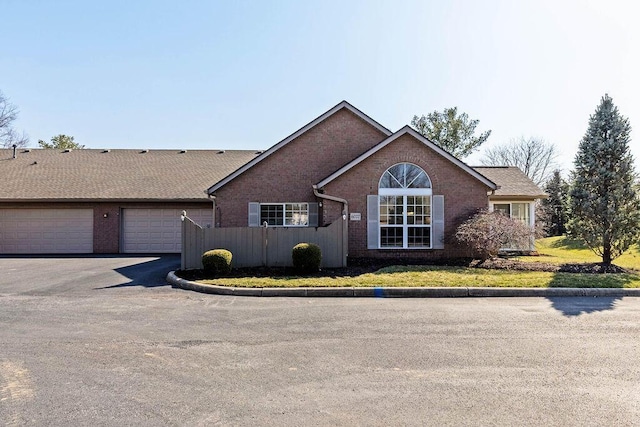 ranch-style house with brick siding, driveway, a garage, and fence