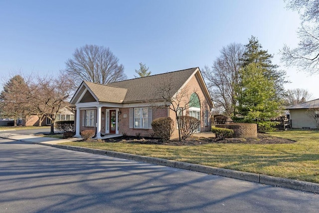 view of front facade with brick siding and a front lawn