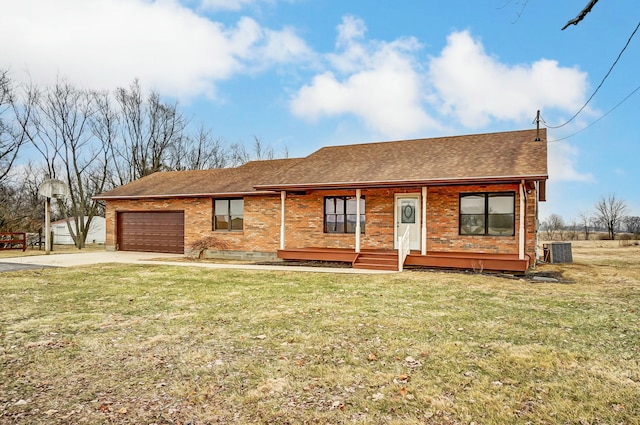 ranch-style house featuring a garage, a front yard, central air condition unit, and a porch