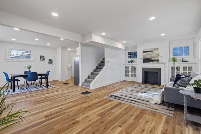 living room with a fireplace and light wood-type flooring