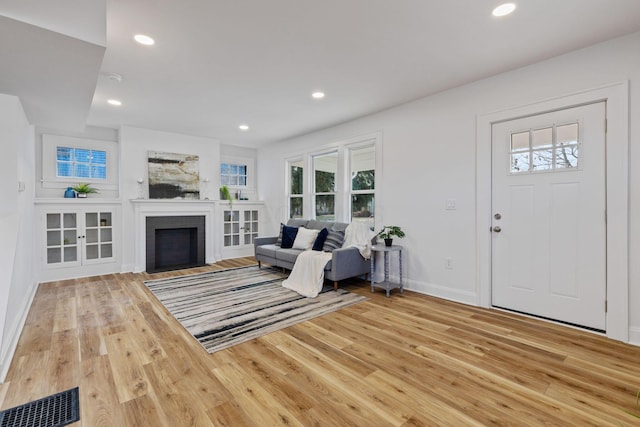 unfurnished living room featuring a brick fireplace and hardwood / wood-style floors