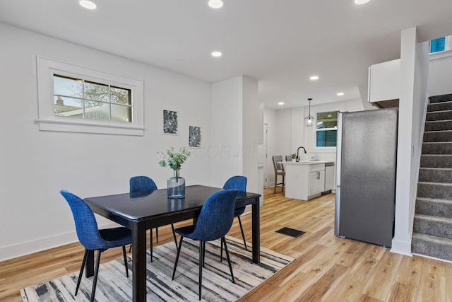 dining area with sink, a wealth of natural light, and light hardwood / wood-style flooring