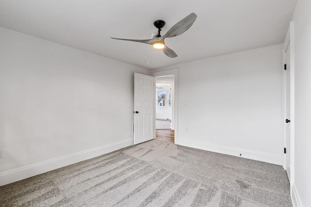 carpeted spare room with ceiling fan