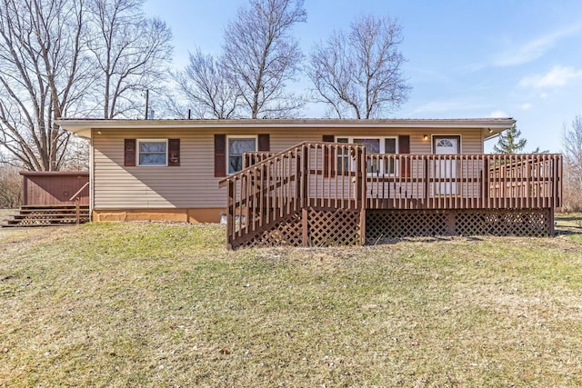 rear view of house with a wooden deck and a lawn