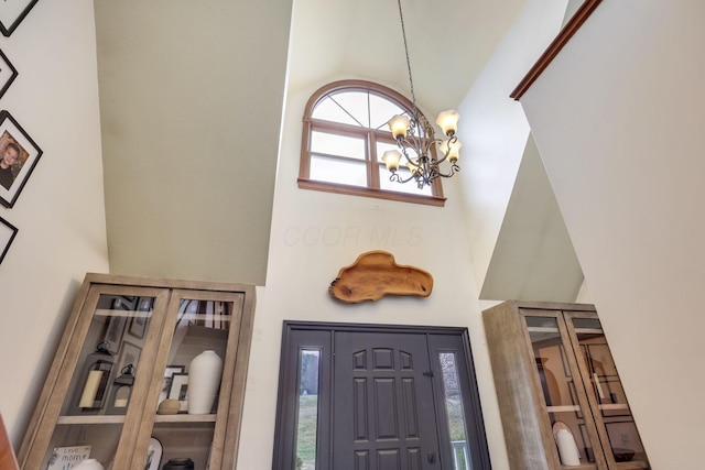 entryway featuring high vaulted ceiling and a notable chandelier