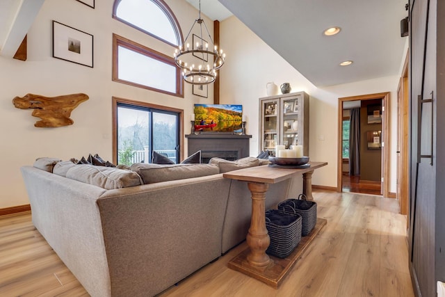 living room featuring a fireplace, light hardwood / wood-style floors, and a high ceiling