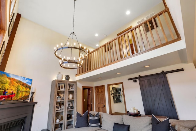 living room featuring a high ceiling, a barn door, and a chandelier