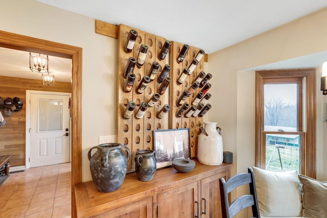 wine cellar featuring light tile patterned flooring and wooden walls