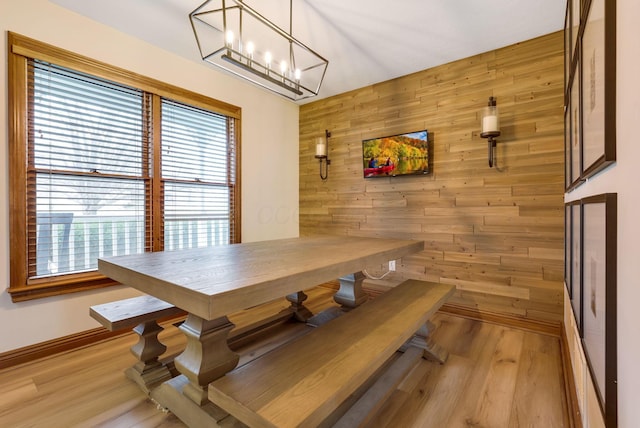 dining space featuring light hardwood / wood-style flooring and wood walls