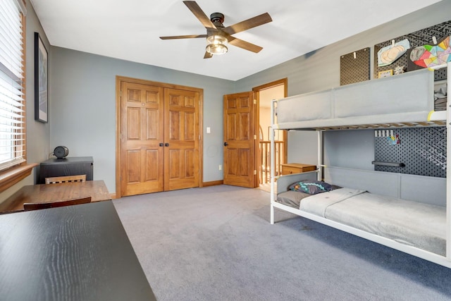 carpeted bedroom with a closet and ceiling fan