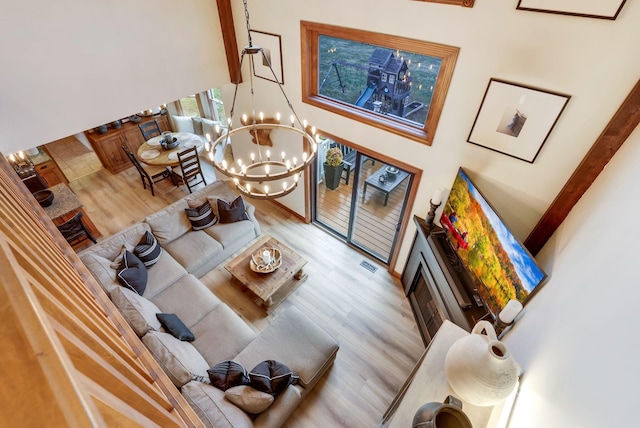 living room featuring a chandelier and light wood-type flooring