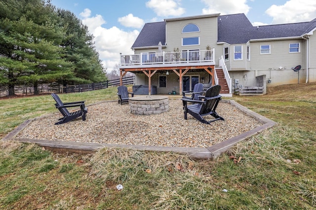 back of house with a yard, a deck, and a fire pit