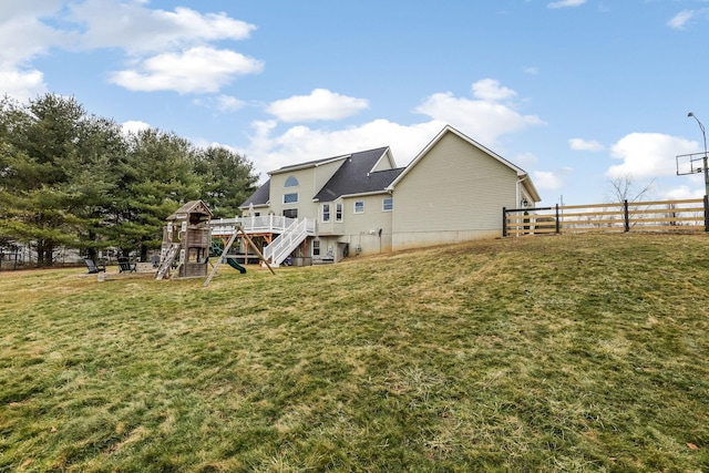 back of property featuring a playground and a yard