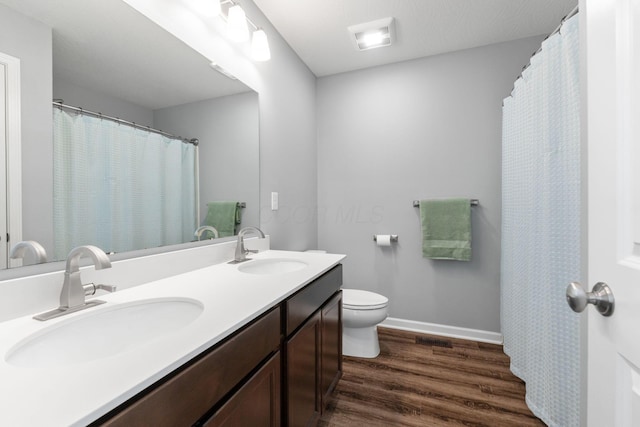 full bathroom featuring wood finished floors, a sink, toilet, and baseboards