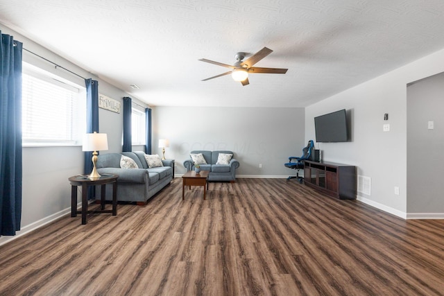 living area with visible vents, baseboards, and wood finished floors