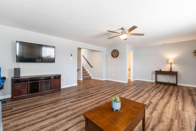 living area with baseboards, visible vents, stairway, and wood finished floors