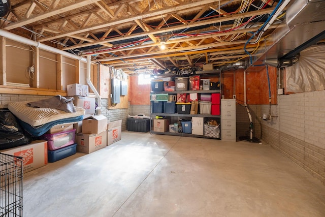 basement with electric panel and brick wall