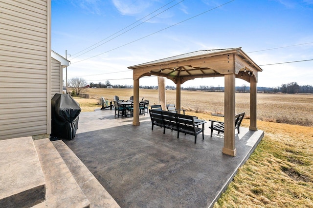 view of patio / terrace featuring a rural view, a gazebo, outdoor dining area, and area for grilling