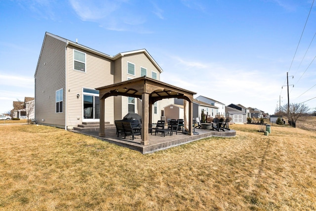 rear view of property featuring entry steps, a gazebo, a lawn, and a patio area