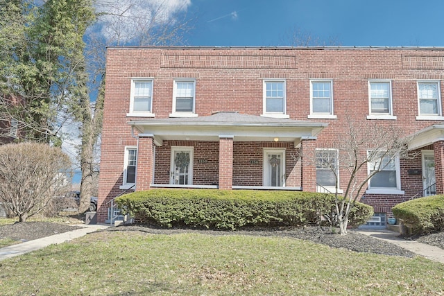 view of property featuring a front yard and brick siding