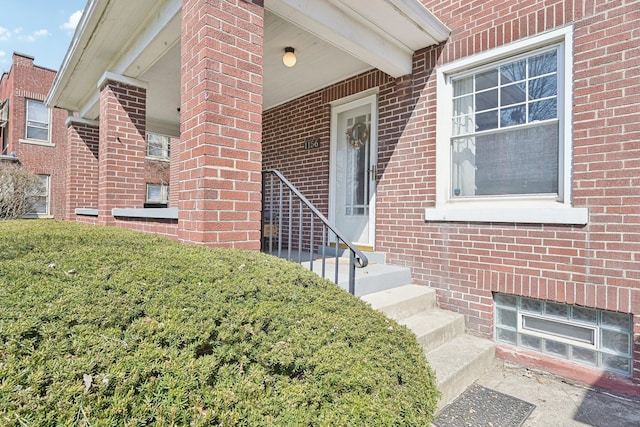 view of exterior entry featuring brick siding