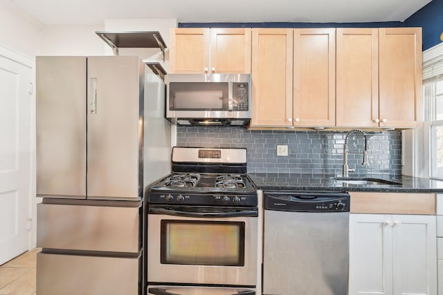 kitchen with light brown cabinets, a sink, tasteful backsplash, appliances with stainless steel finishes, and light tile patterned floors