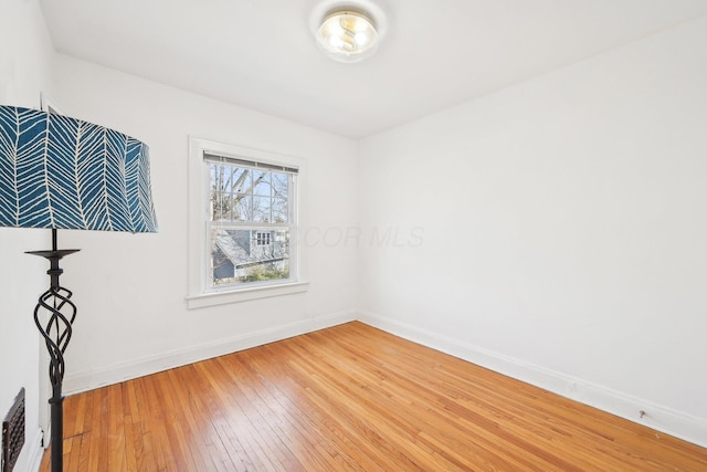 empty room featuring visible vents, baseboards, and light wood-type flooring