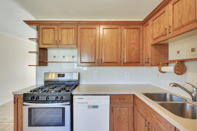 kitchen featuring stainless steel gas stove, sink, decorative backsplash, and dishwasher