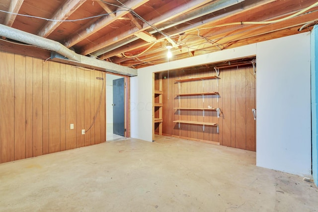 basement featuring wooden walls