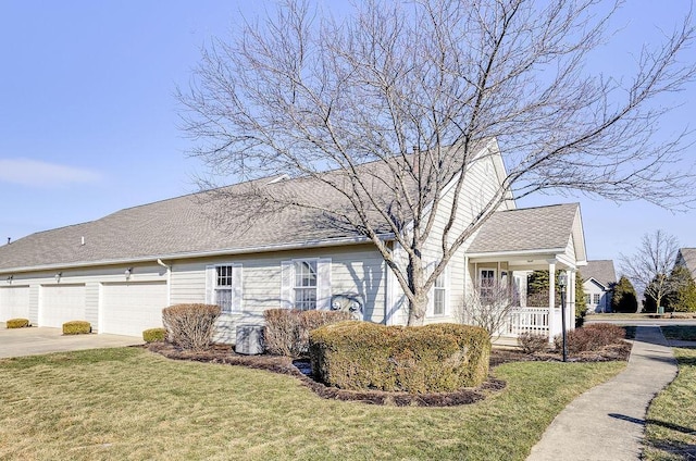 view of side of property featuring a garage, covered porch, and a lawn