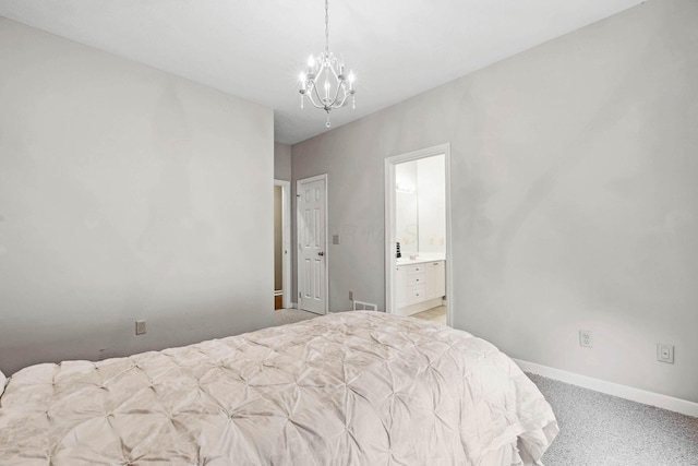 bedroom featuring ensuite bathroom, a chandelier, and light carpet