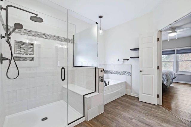 bathroom with ceiling fan, plus walk in shower, and hardwood / wood-style floors