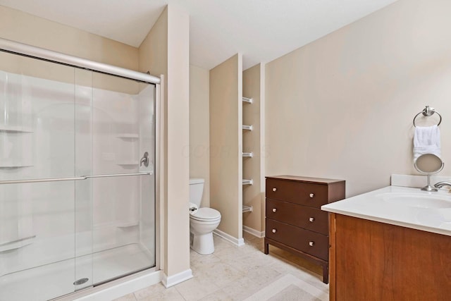 bathroom with vanity, a shower with shower door, tile patterned floors, and toilet