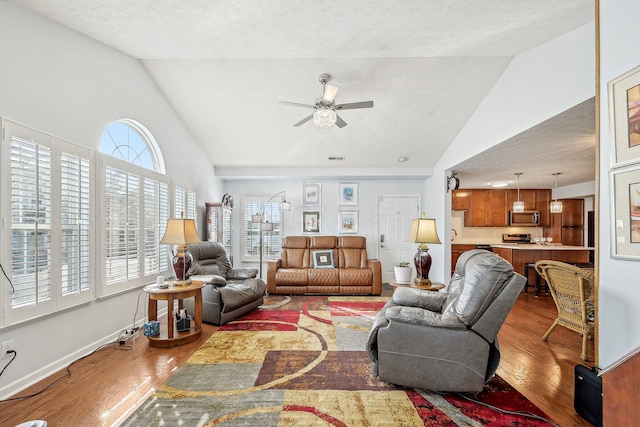 living room featuring high vaulted ceiling, hardwood / wood-style floors, a textured ceiling, and ceiling fan