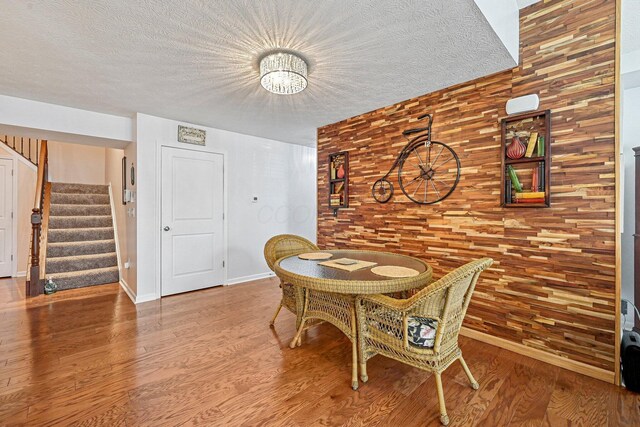 dining space with hardwood / wood-style flooring and a textured ceiling